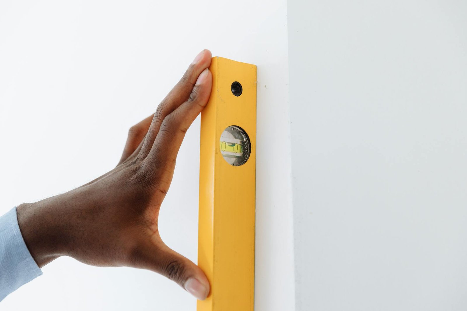 Person marking wall studs and layout lines for garage storage installation