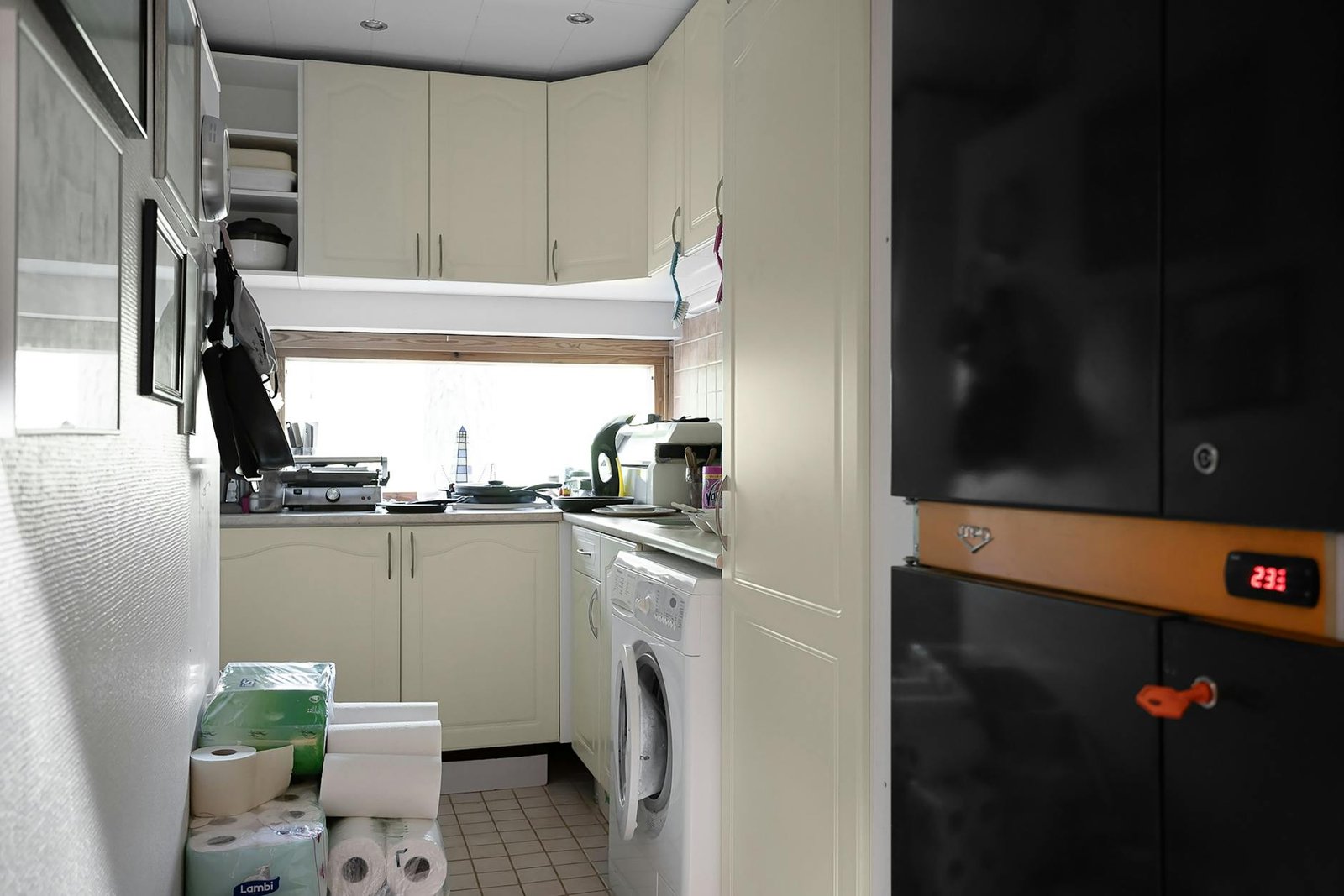 Cabinet door interior showing hooks holding mugs and door organizer with glasses