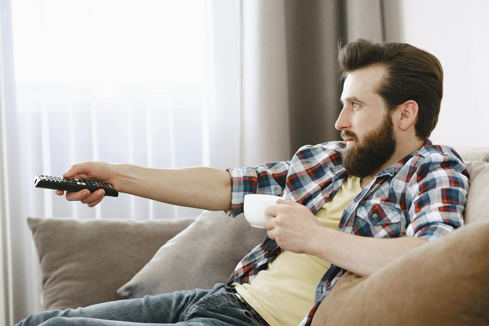 Person folding laundry while watching TV in living room