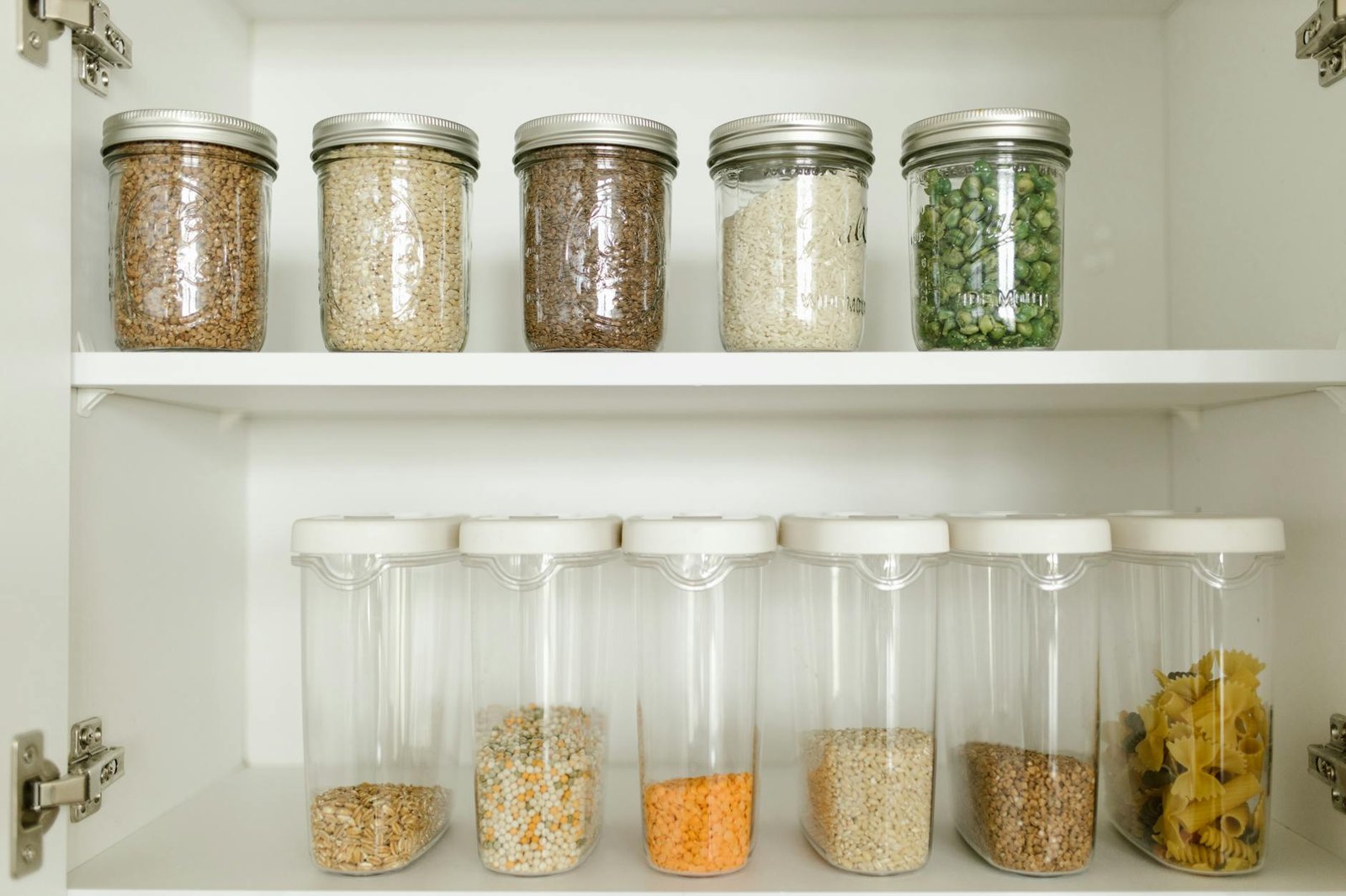 Clear containers with organized snacks on pantry shelves