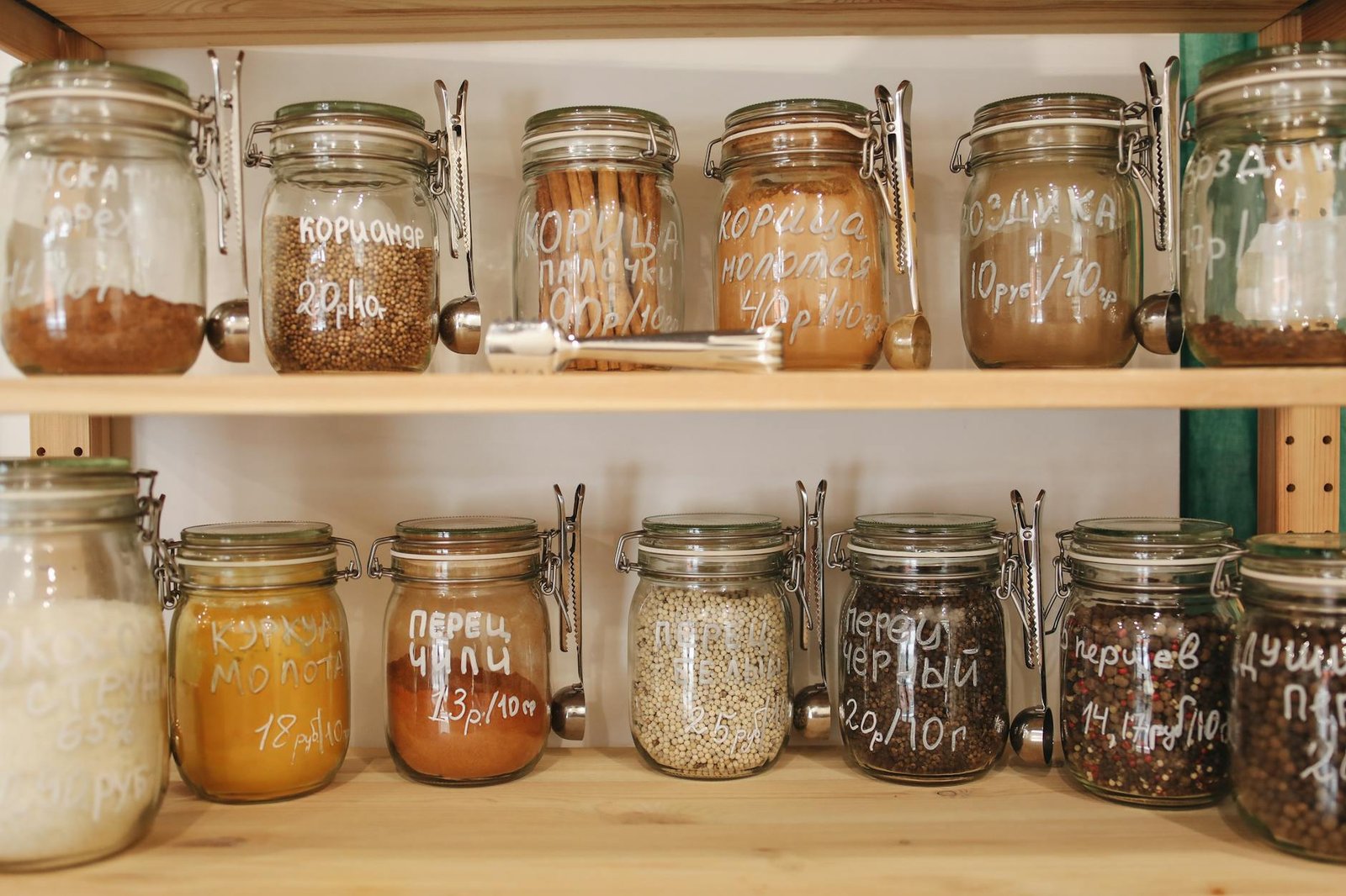 Organized spice drawer with tiered containers and inventory notepad