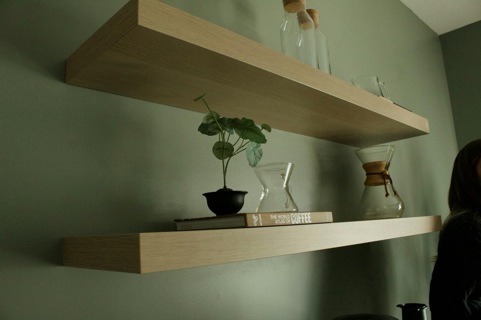 Bedroom wall with floating shelves and door hooks for vertical storage
