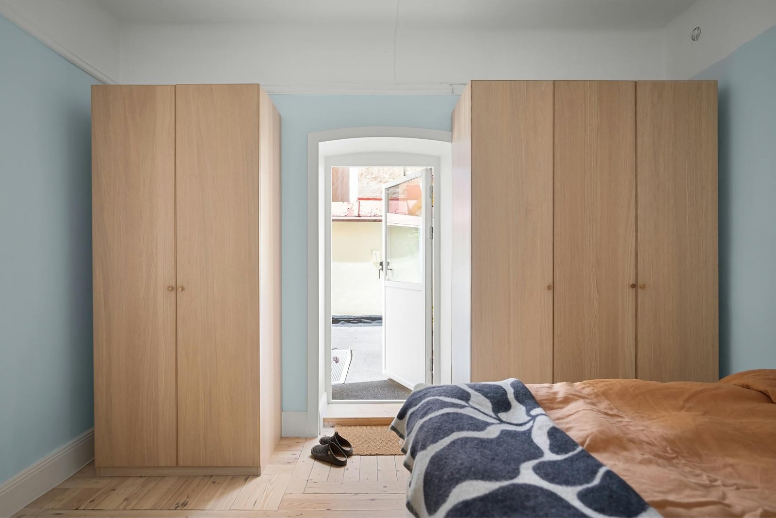 Bedroom door with over-door organizer and hooks maximizing storage space