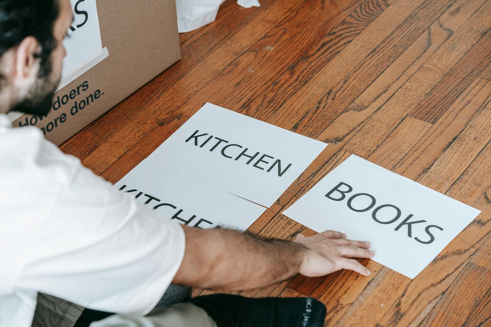 Kitchen cabinet organization with items being sorted into keep, donate, and trash piles